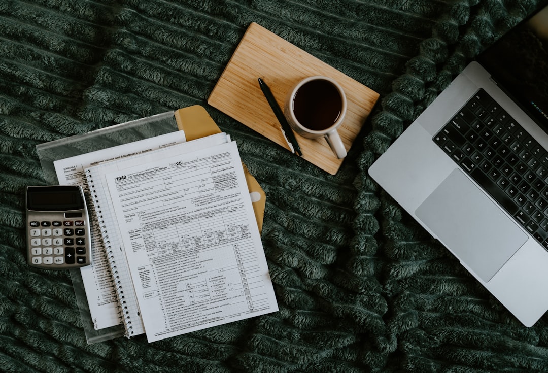 laptop-papers-calculator-and-coffee-on-blanket-kpcghryiykg
